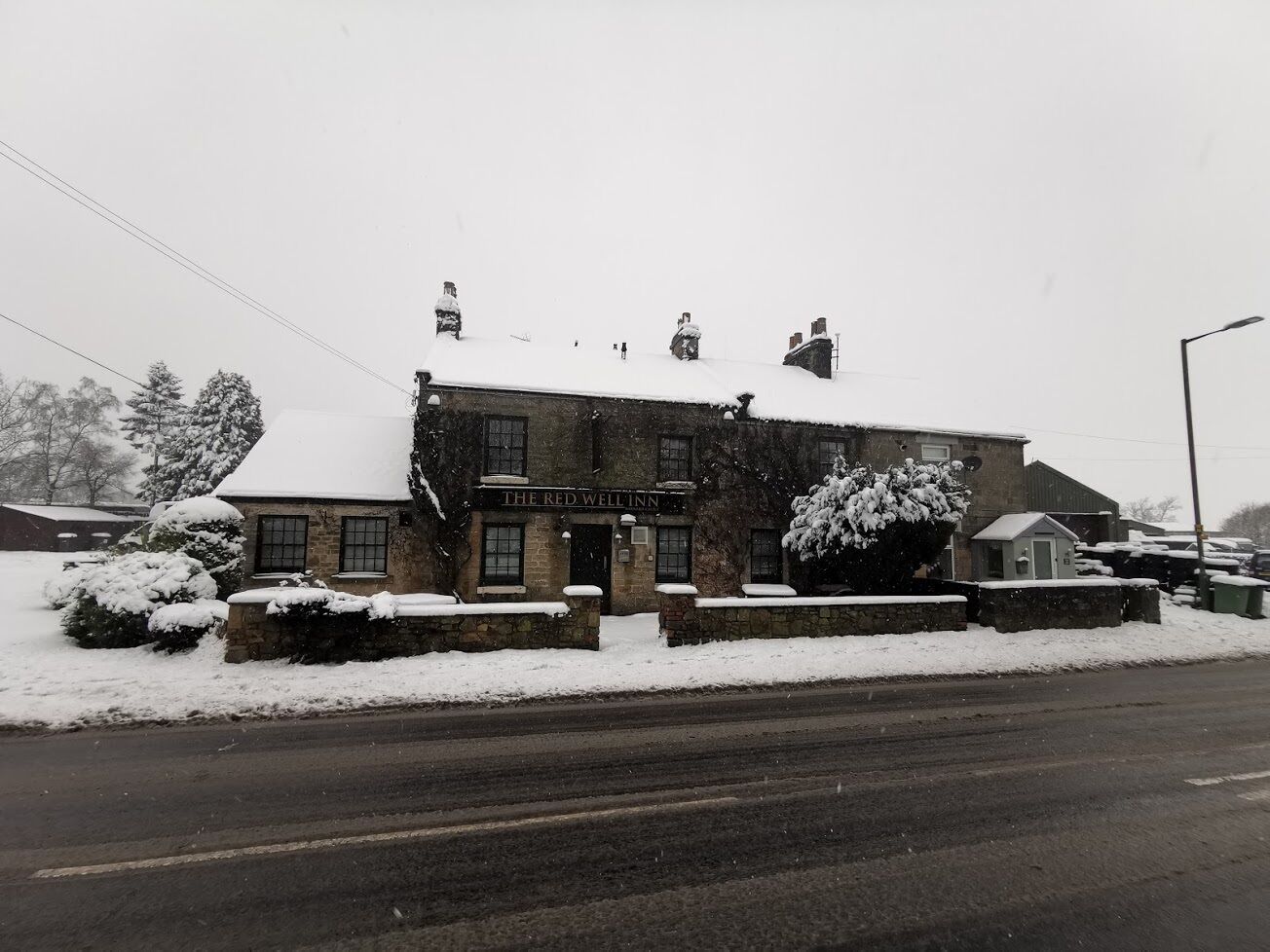 A stone building with a sign reading "The Red Well Inn."