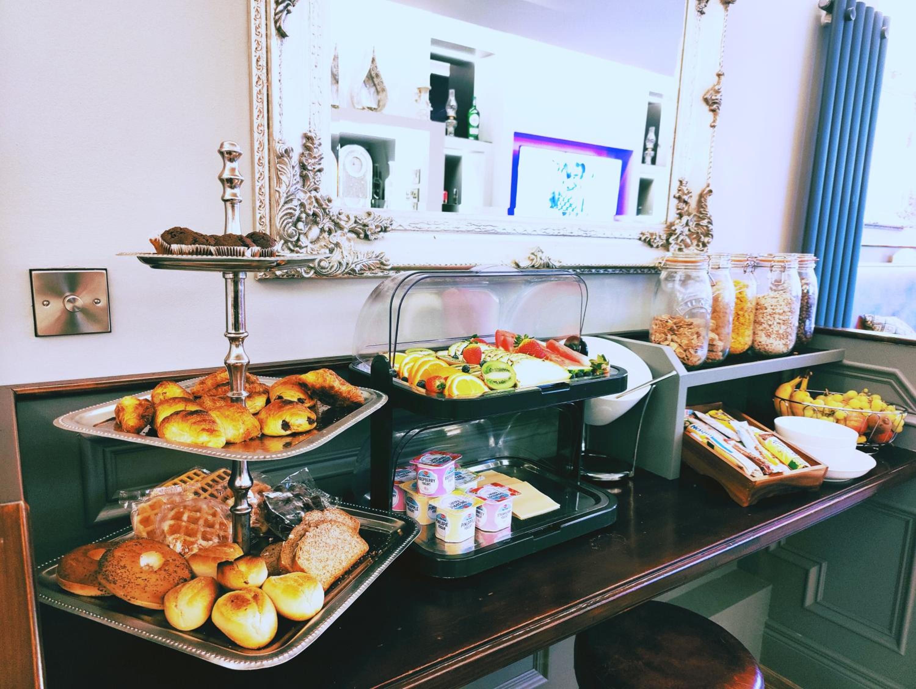 A buffet setup with various food items and condiments.