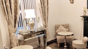 A room with a round table, two armchairs, a sofa, a decorative mirror, and curtains. - Serendipity House (Londonderry)