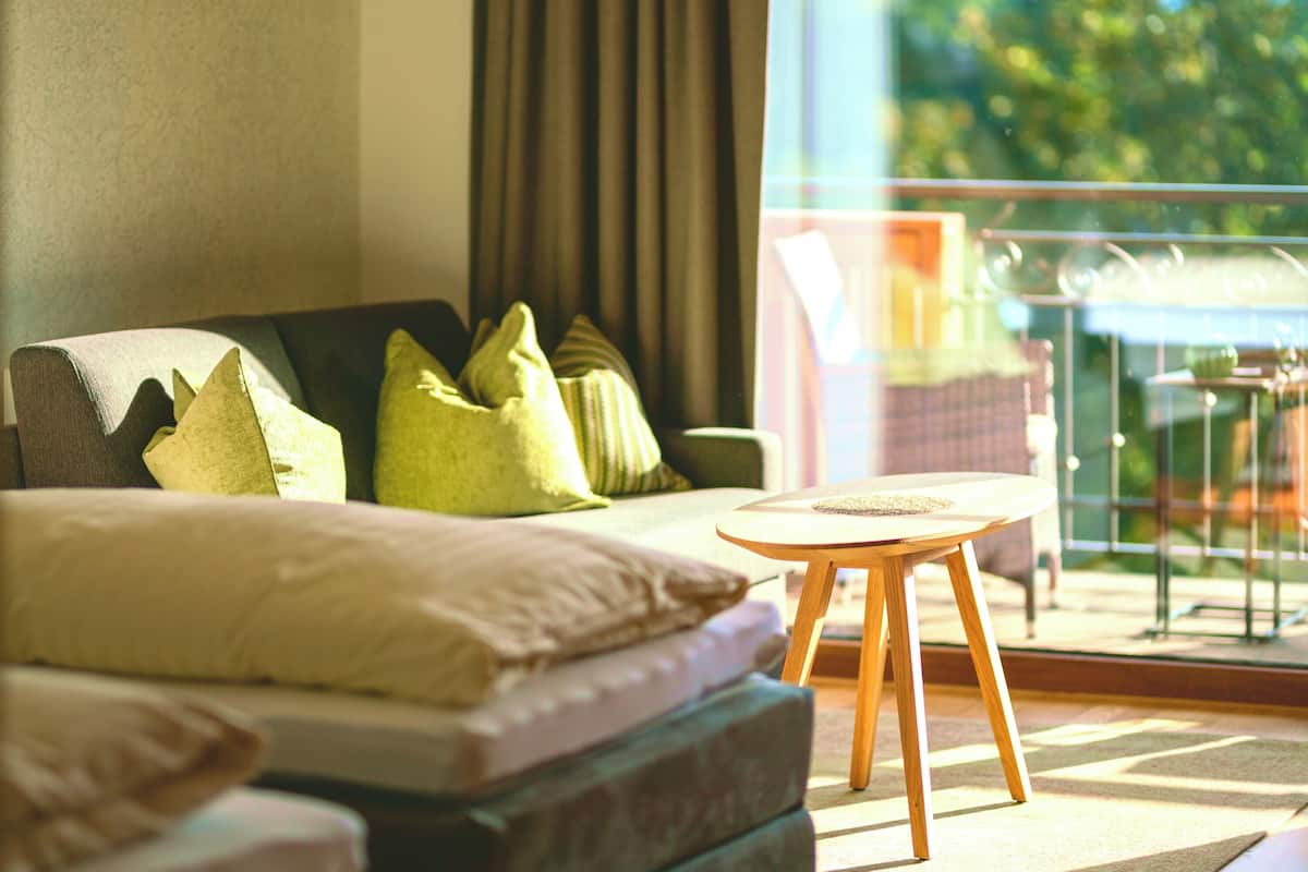 A modern living room with a sofa, cushions, and a small wooden table.