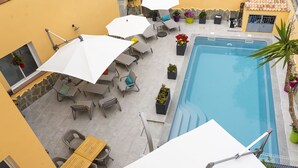 An outdoor pool area with lounge chairs, umbrellas, and potted plants. - Hotel A Casa di Maria Cicilia (Ghisonaccia)