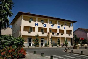 Un hotel de dos pisos con balcones y un letrero que indica que se llama María Cettina.
