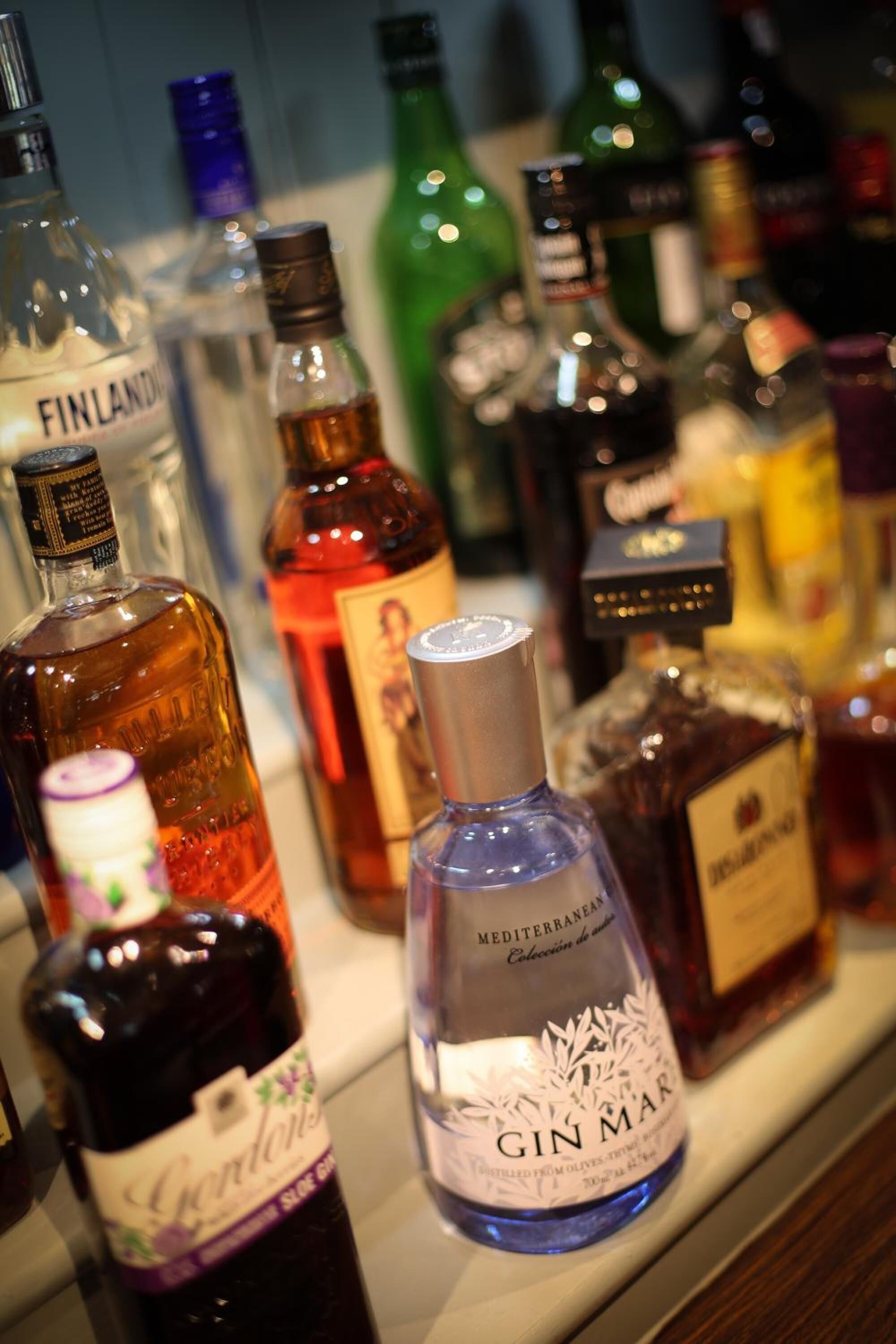 A variety of liquor bottles on a shelf.