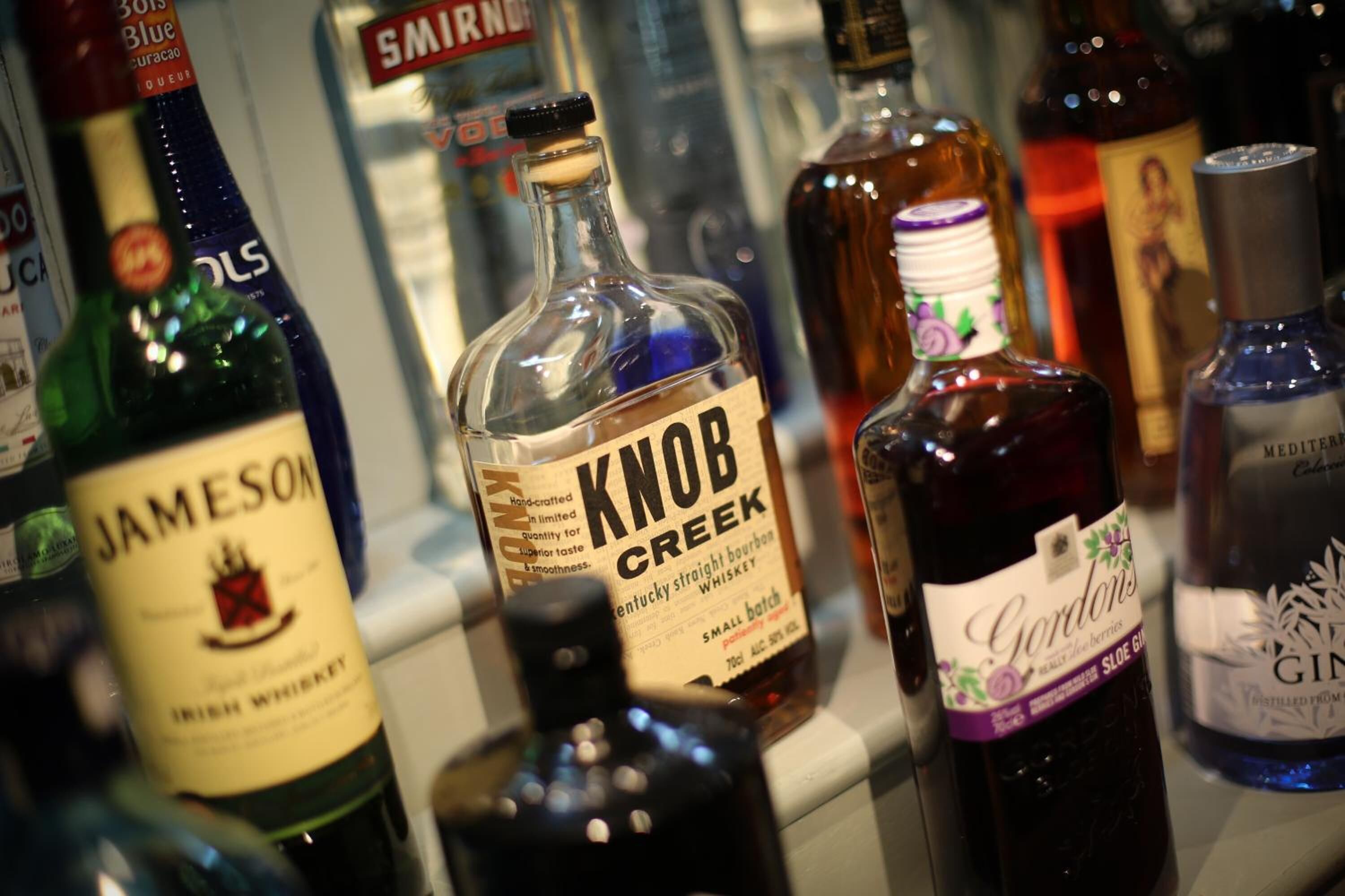 A variety of liquor bottles on a shelf.