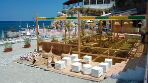 A beachside hotel with outdoor seating, a pool area, and a view of the sea. - Villaggio Cirucco (Milazzo)