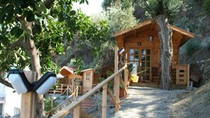 A wooden cabin with a sloped roof, a wooden deck, and a staircase leading to the entrance. - Villaggio Cirucco (Milazzo)