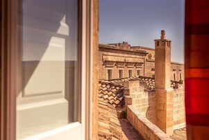 Vista de um edifício histórico com fachada de pedra e uma torre imponente.