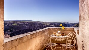 Un balcón con una mesa dispuesta para el desayuno, con vistas a un paisaje pintoresco.