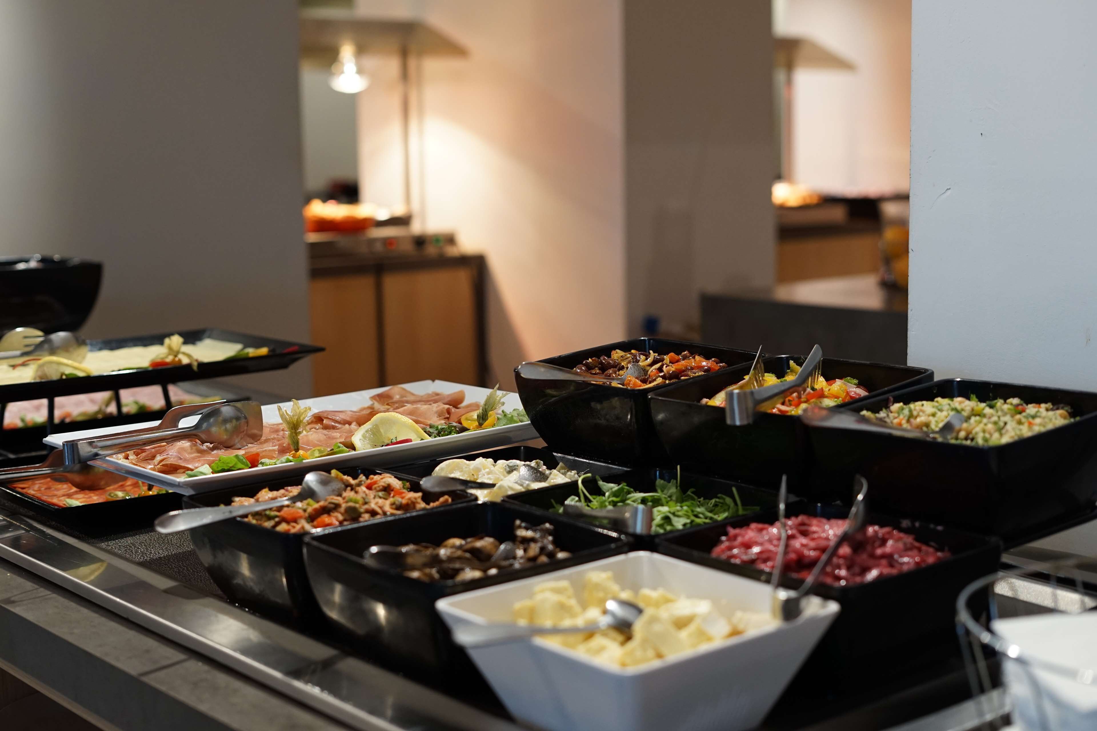 A buffet with various food options including meats, salads, and other dishes.