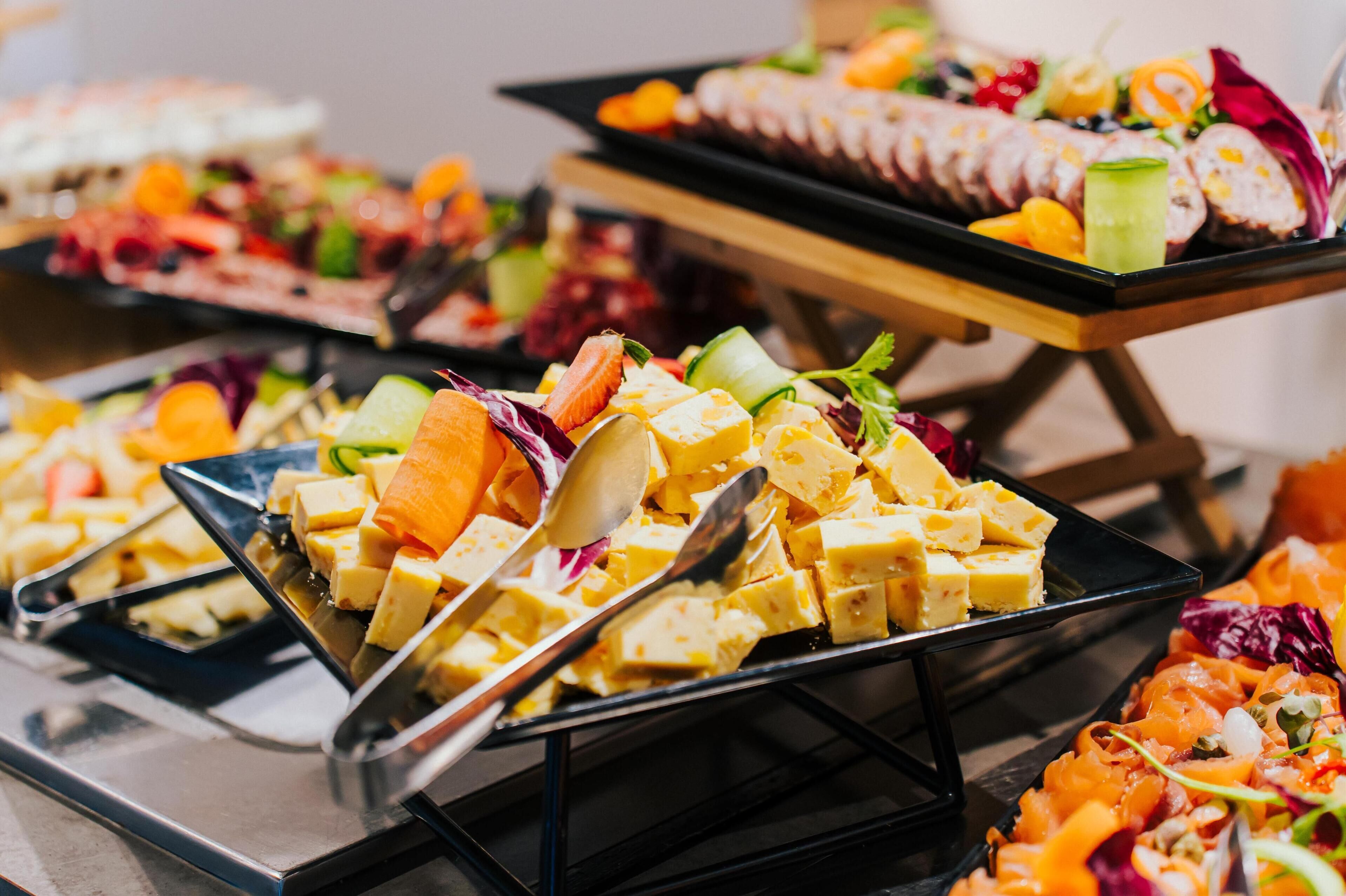 A buffet with various food items including fruit, cheese, and salads.