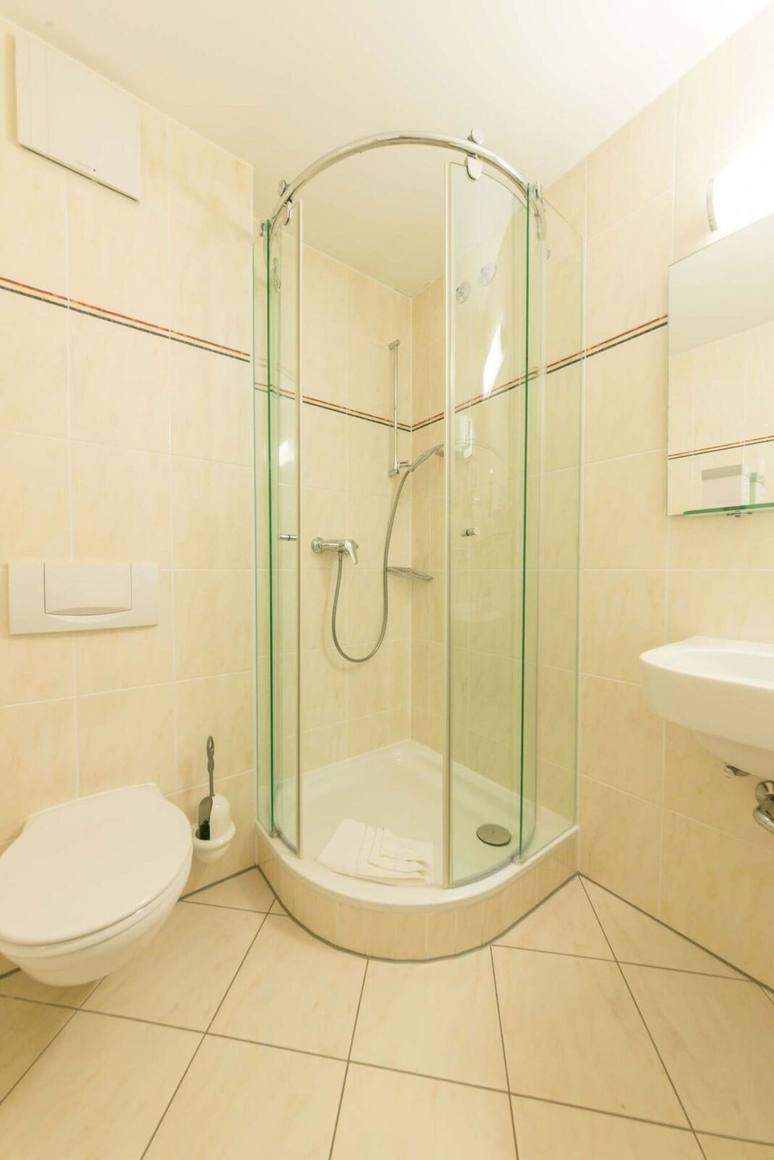 Un baño moderno con ducha de vidrio, inodoro y lavamanos.