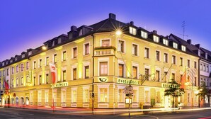 A historic hotel with a classic European facade, multiple stories, and a prominent corner location. - Romantik Hotel zur Post (Fuerstenfeldbruck)