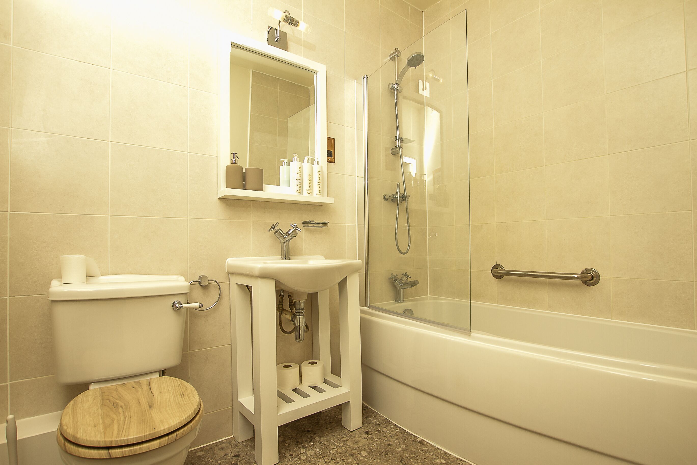A bathroom with a toilet, sink, and shower.