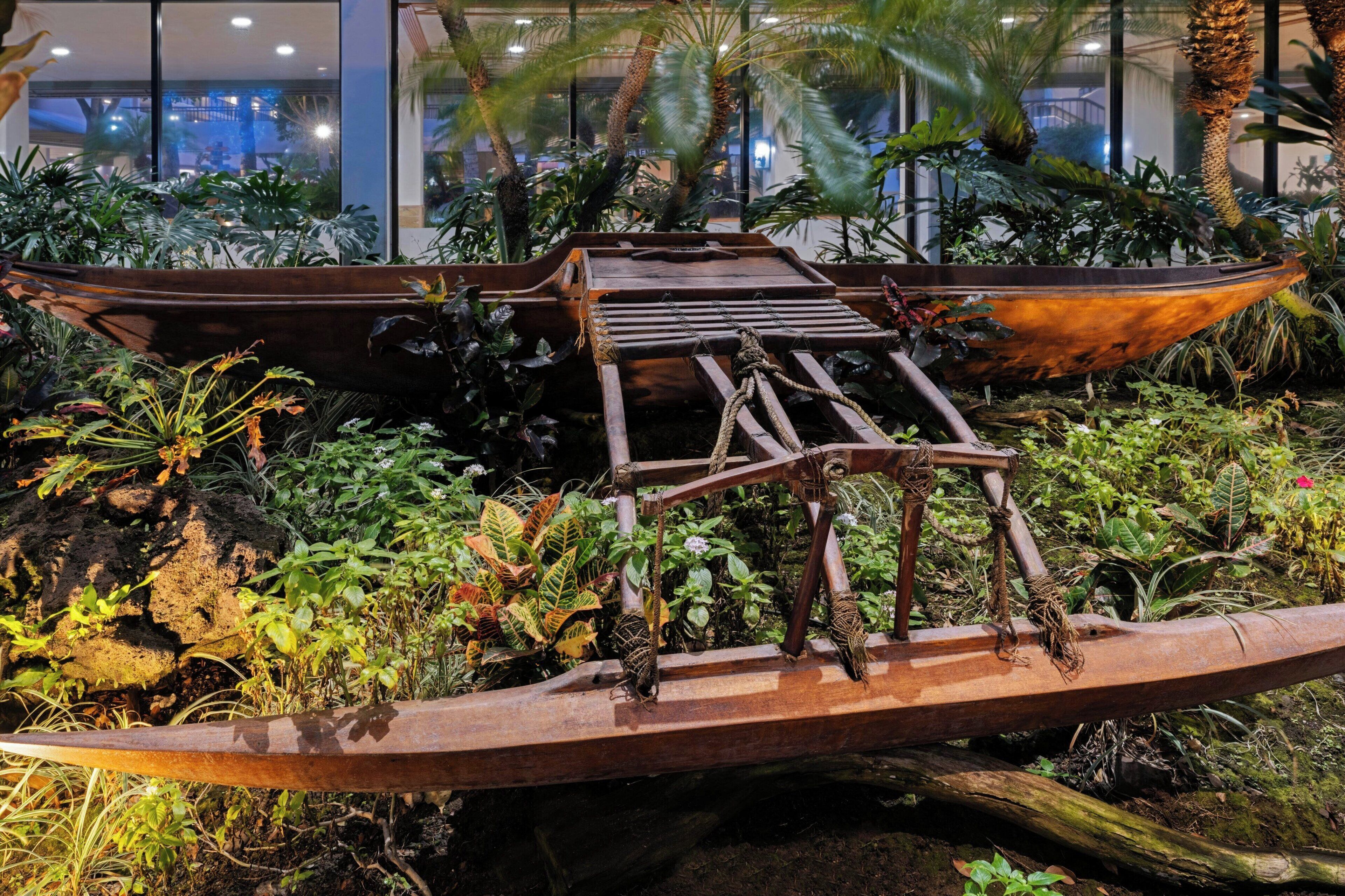 Une structure en forme de bateau, entourée d’une végétation luxuriante et de plantes.