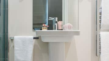 A bathroom with a white sink, a mirror, and a towel rack.