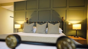 A neatly made bed with a headboard, two bedside lamps, and a nightstand. - Waveney House Hotel (Beccles)