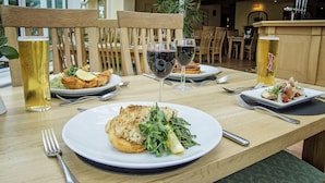 A dining table with plates of food, wine glasses, and beer cans. - Waveney House Hotel (Beccles)