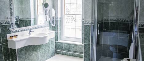 A bathroom with a sink, mirror, and shower.