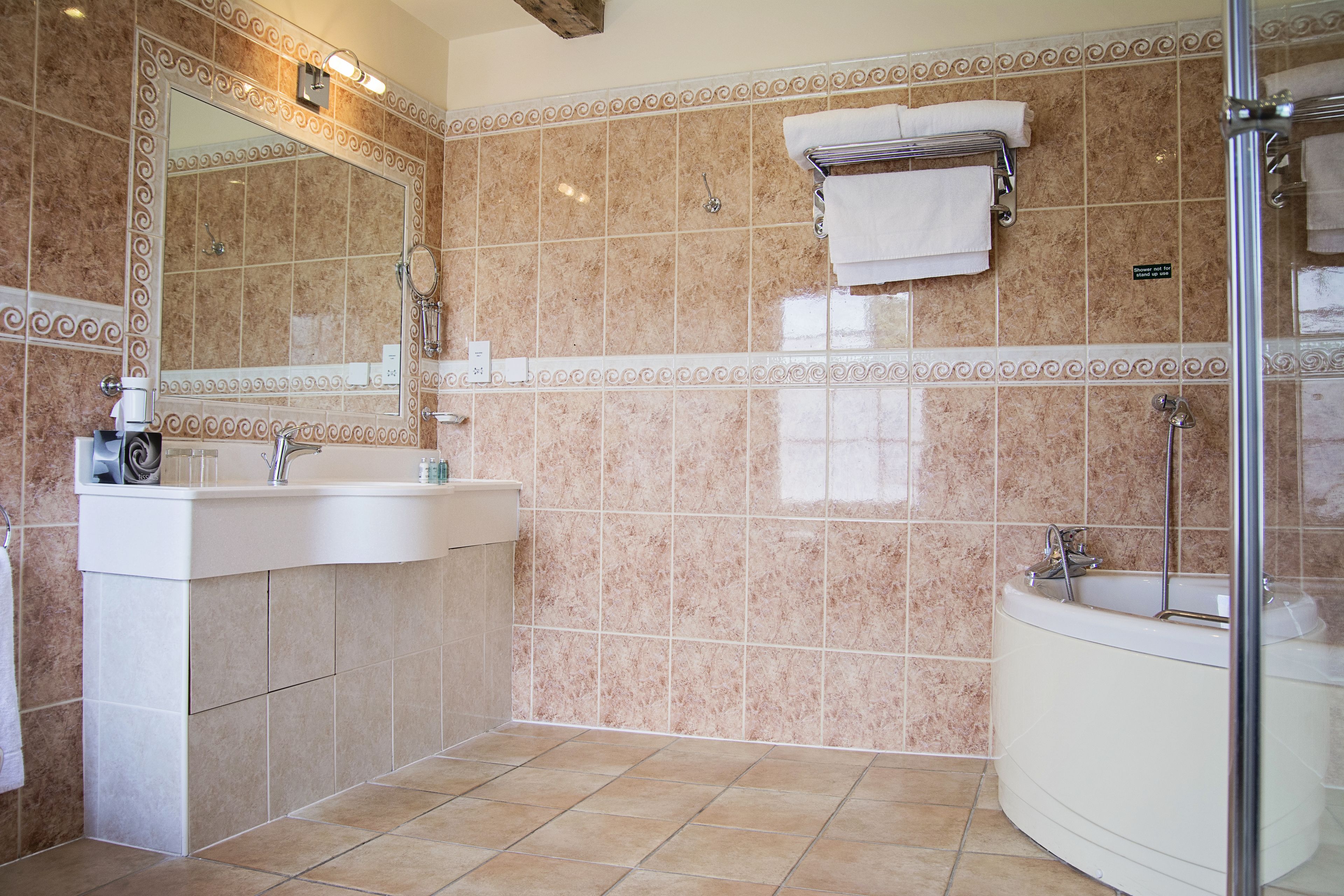 A bathroom with a sink, mirror, and bathtub.
