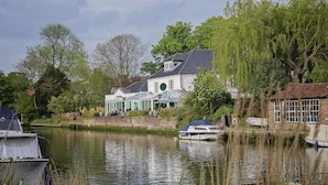 A riverside house with a large window and a covered terrace. - Waveney House Hotel (Beccles)