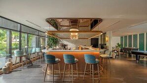 A modern bar area with a curved counter, bar stools, and a pool table. - Anantara Mui Ne Resort (Mui Ne)