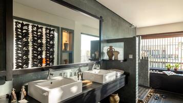 A modern bathroom with two sinks, a large mirror, and a window with a view.