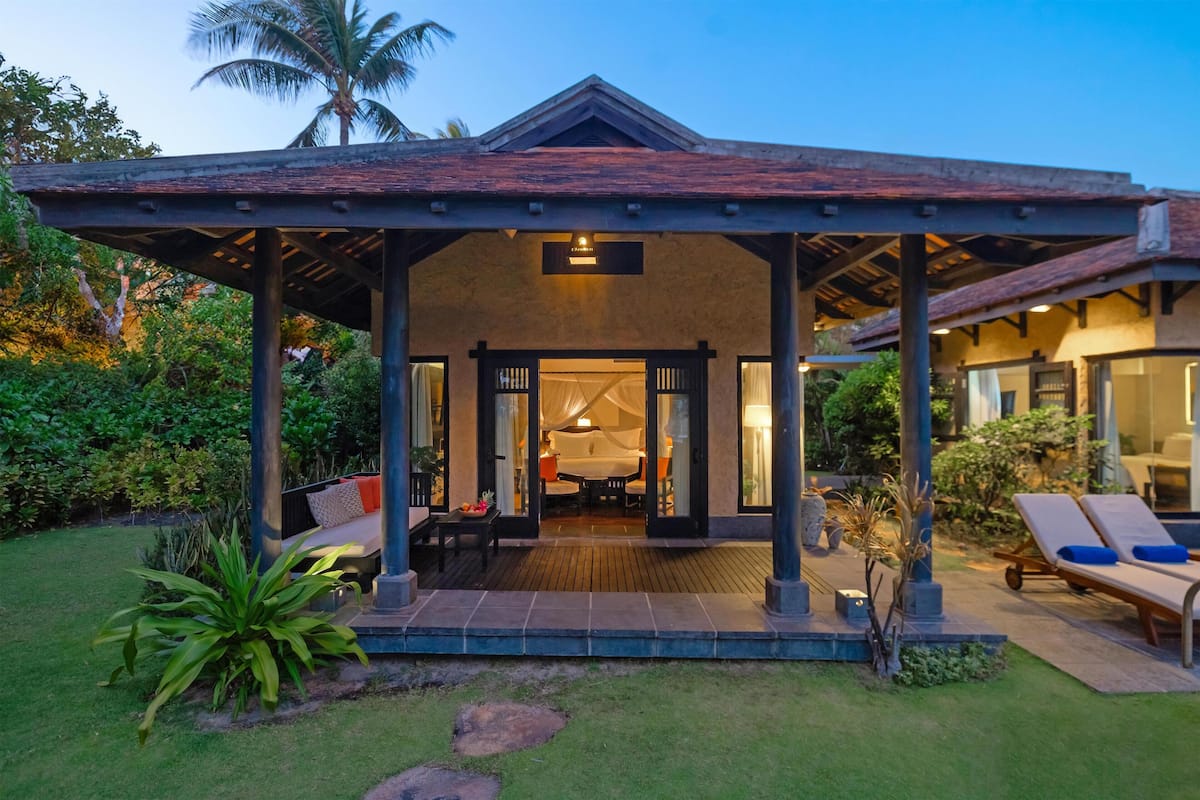 A covered outdoor seating area with a wooden roof, a patio table, and chairs.