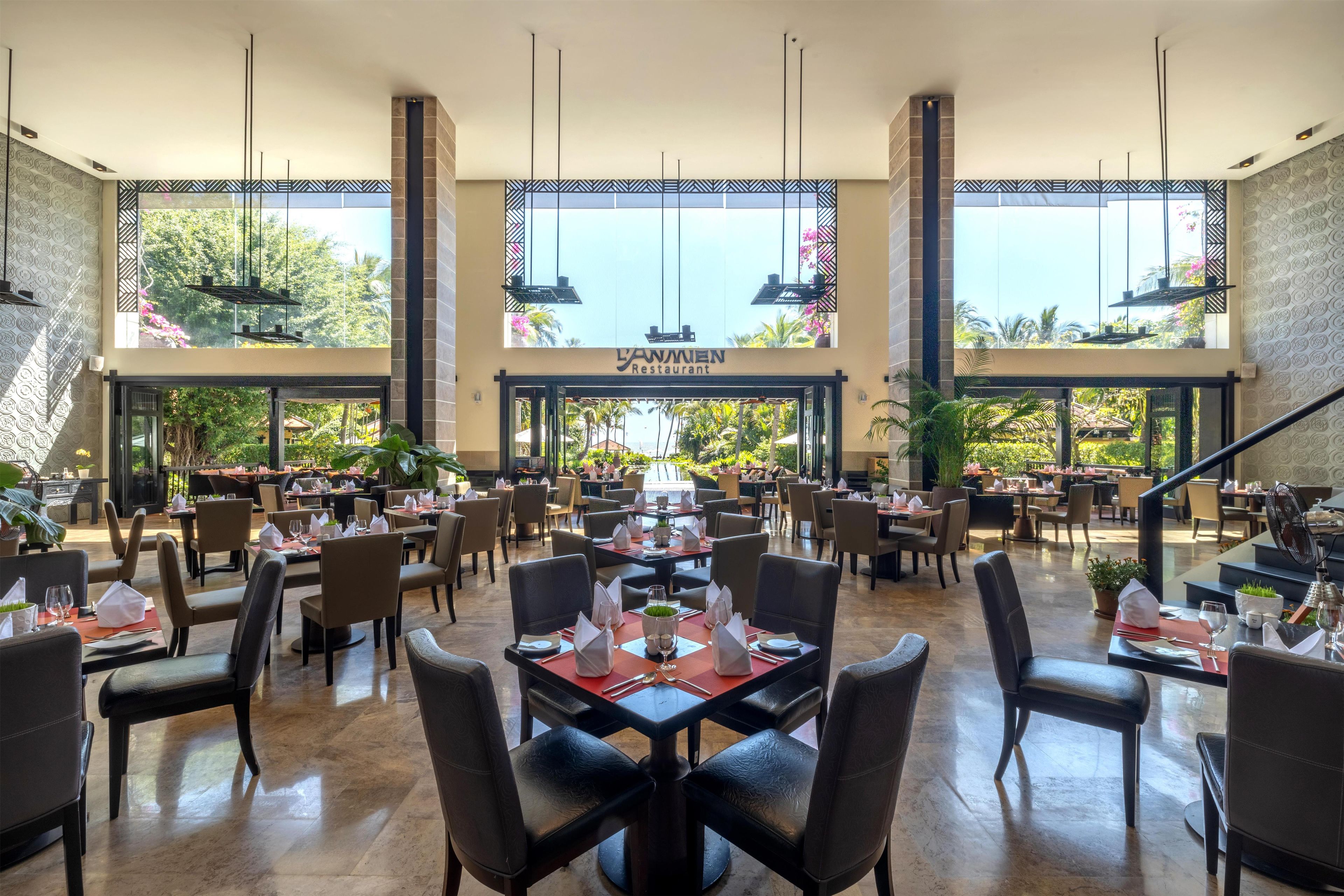 A restaurant with multiple dining areas, large windows, and a view of the outdoors.