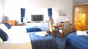 A hotel room with two beds, a TV, a desk with chairs, and a wardrobe. - The Hostelrie at Goodrich (Ross-on-Wye)