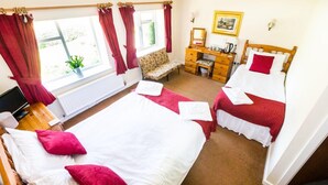 A hotel room with two beds, a desk, a chair, and a window with curtains. - The Hostelrie at Goodrich (Ross-on-Wye)
