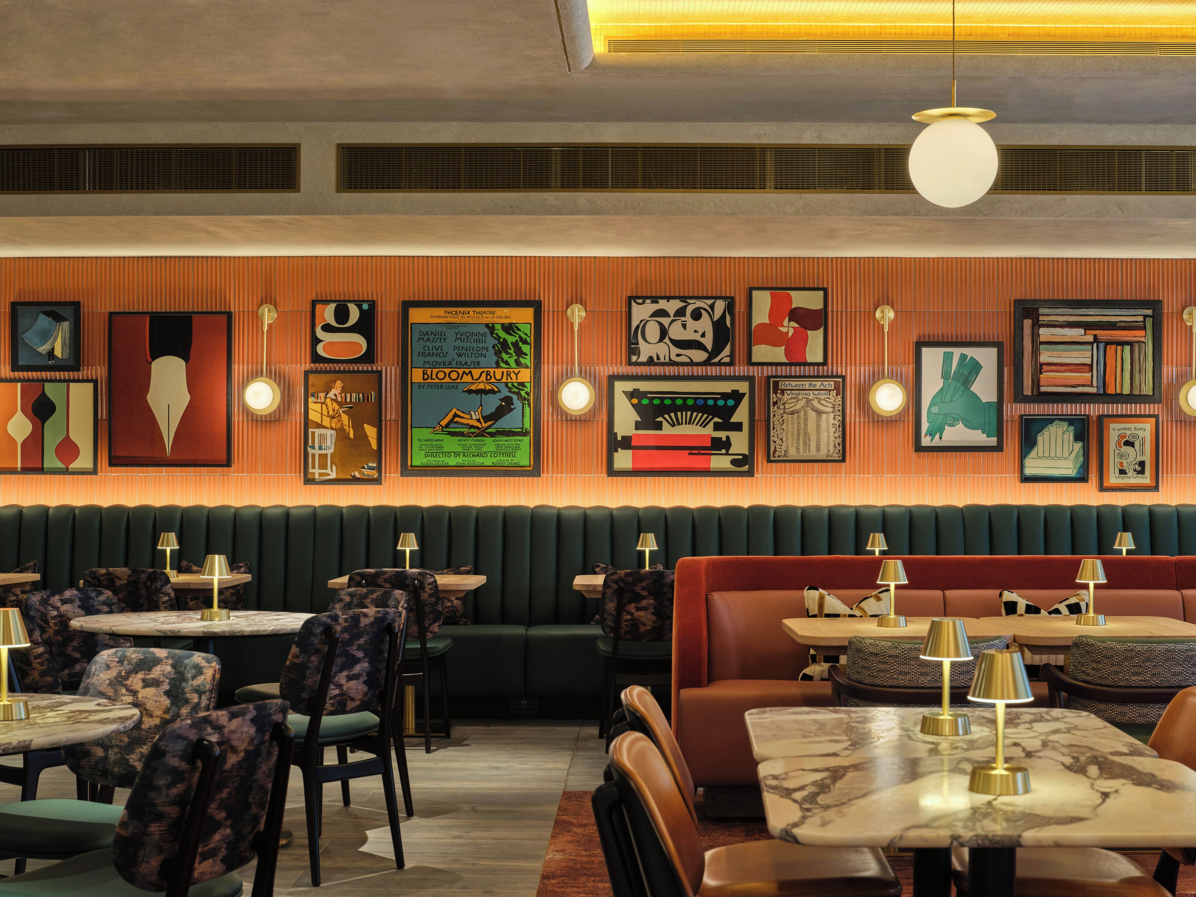 A restaurant interior with booths, round tables, and wall art.