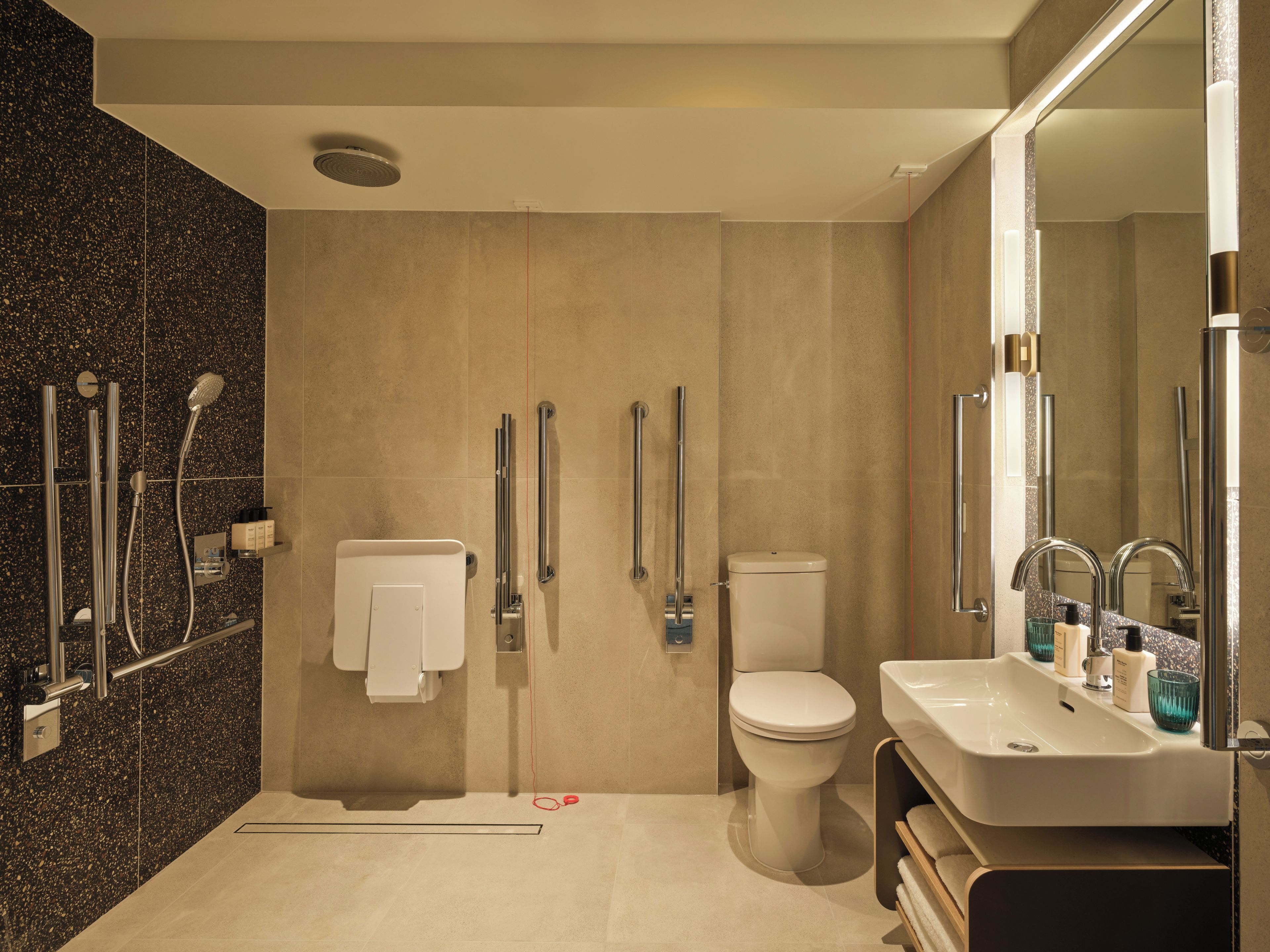 A modern bathroom with a shower, toilet, and sink.