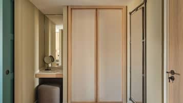 Una habitación con un armario de madera, un espejo y un taburete pequeño.