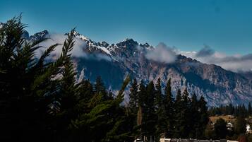 A mountain range with snow-capped peaks and a town in the foreground.