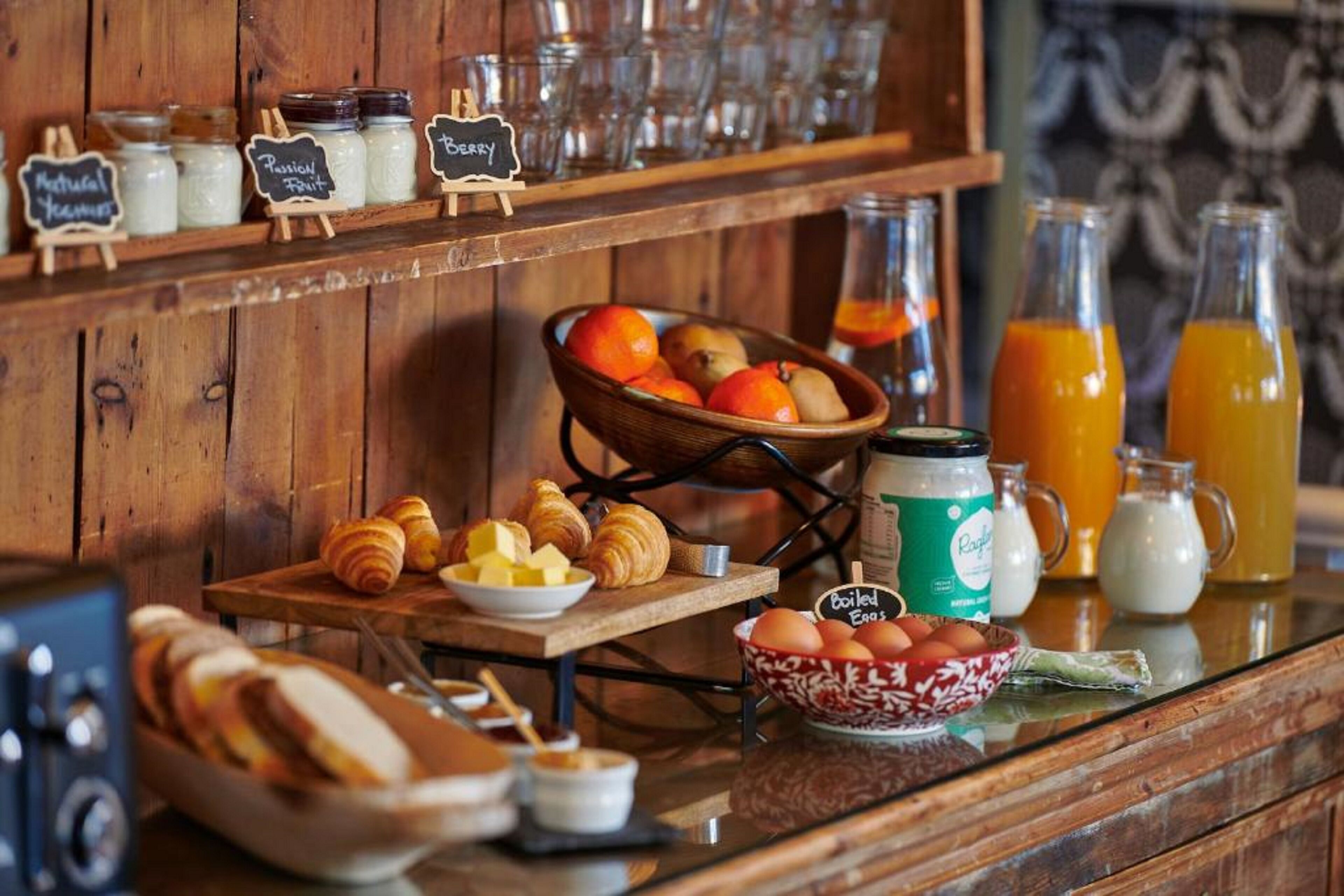 Un bufé de desayuno con bollería, frutas y bebidas.
