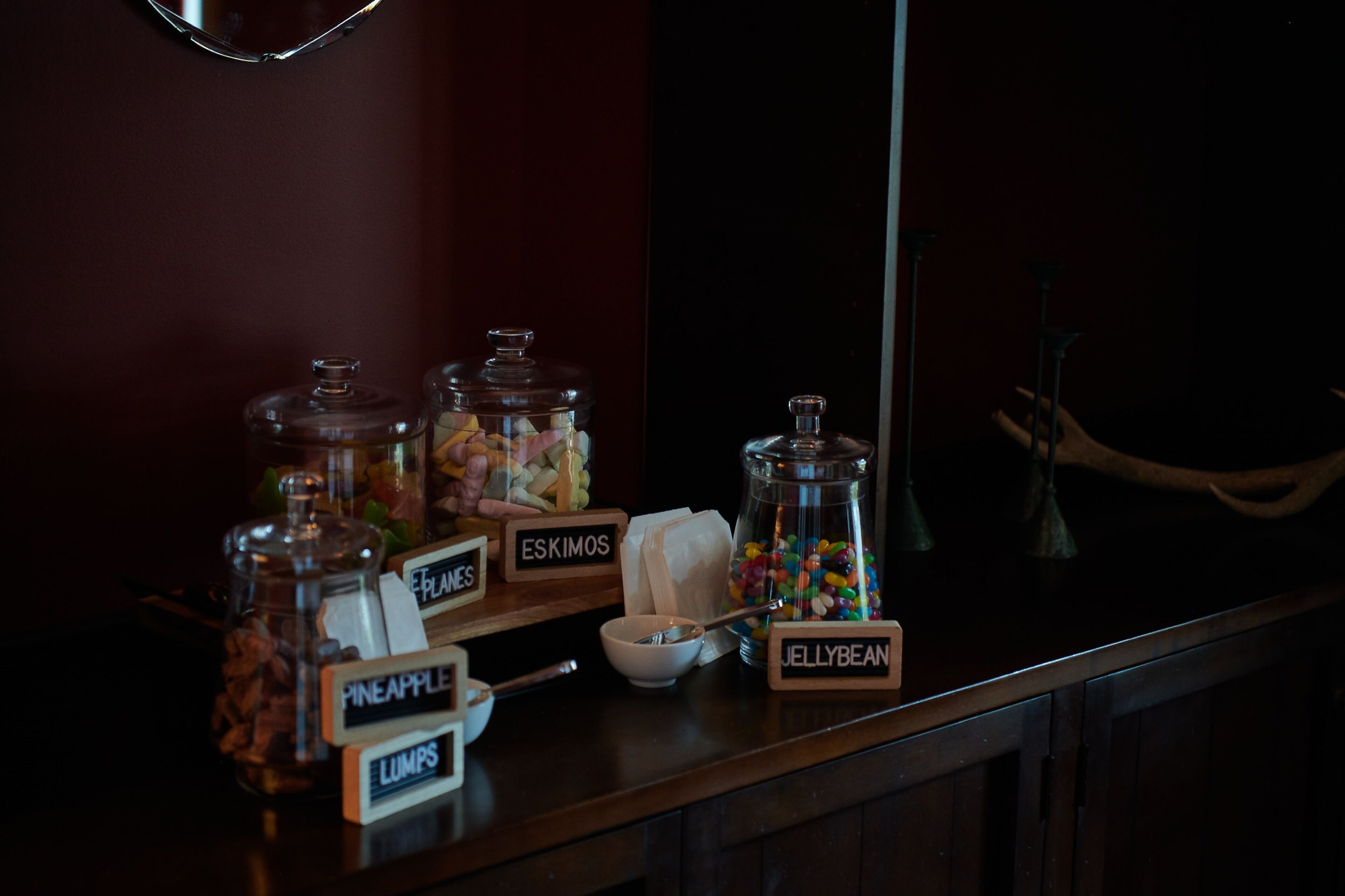 Una barra de dulces con botes etiquetados de diferentes golosinas.
