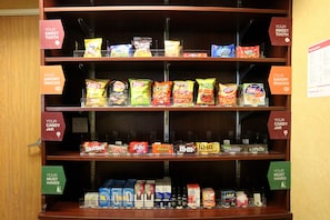 Una repisa con varias bolsas de papas fritas y otros bocadillos.