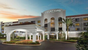 A Courtyard by Marriott hotel with a central courtyard, multiple balconies, and a well-maintained entrance area. - Courtyard By Marriott Stuart (Stuart)