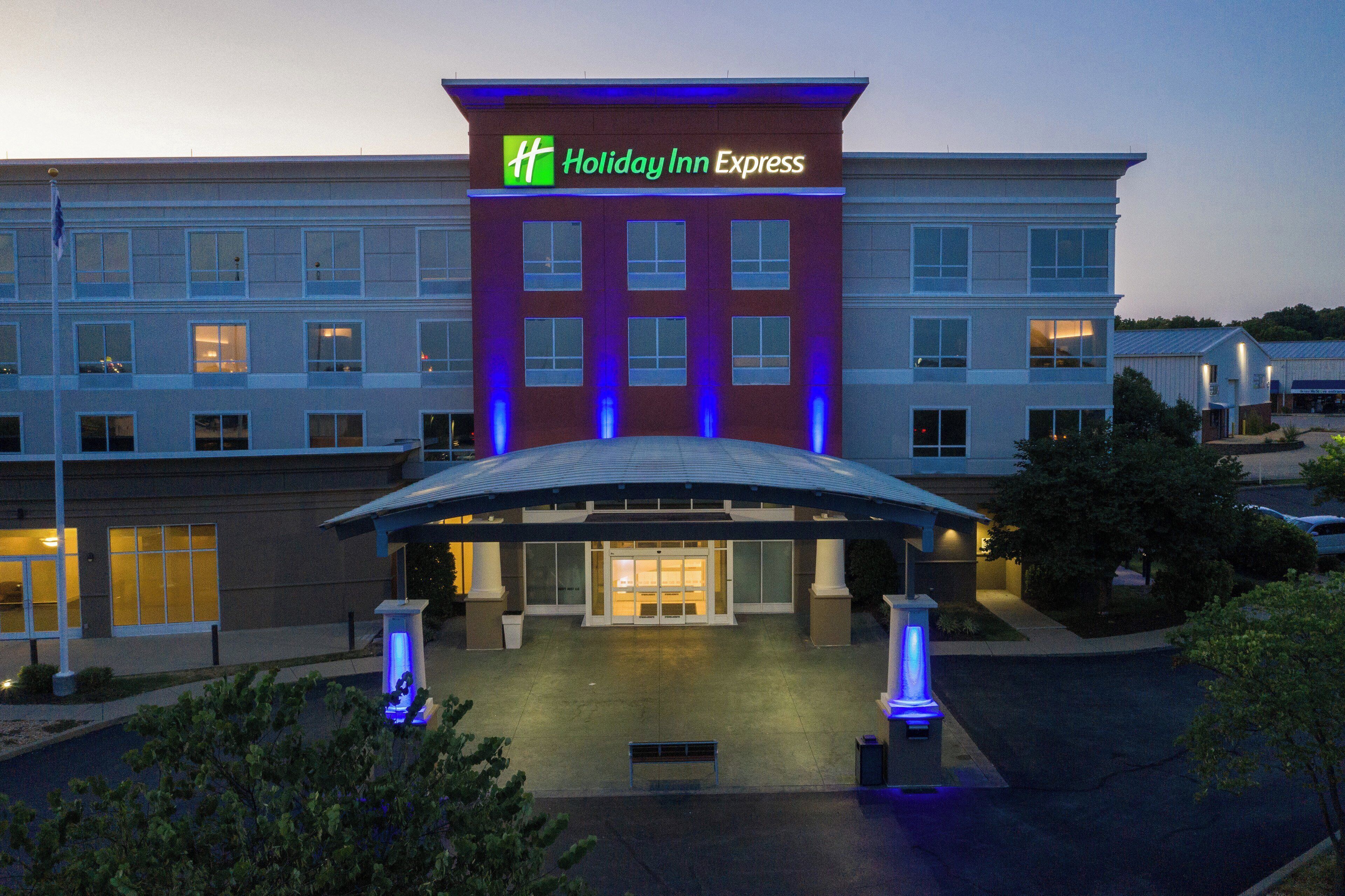 Un hotel Holiday Inn Express con una fachada moderna, varios ventanales y un área de acceso cubierta.
