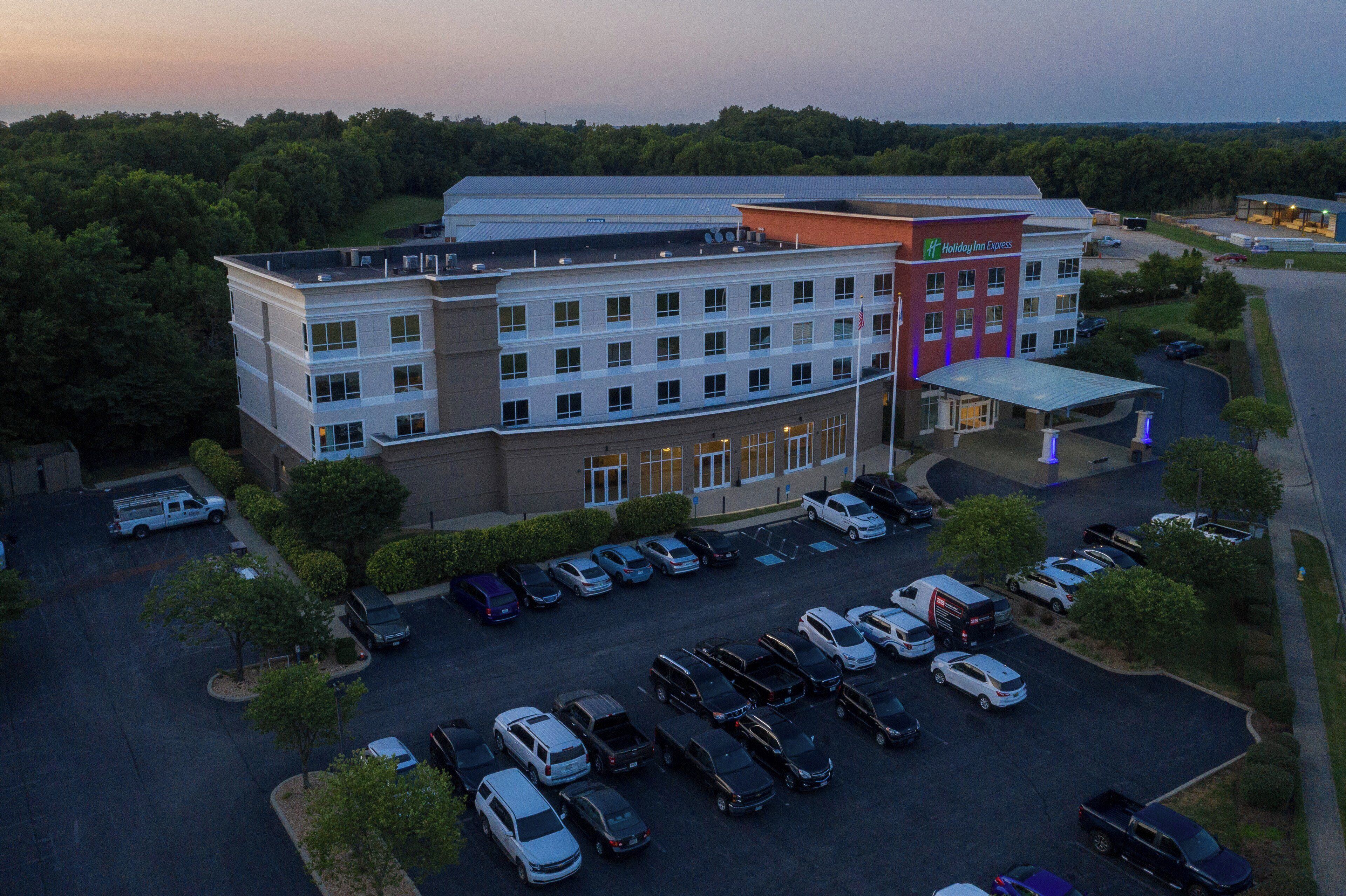 A multi-story hotel with a parking lot full of cars.