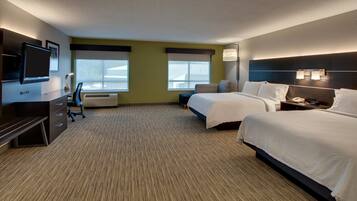 A hotel room with two beds, a desk, a chair, a flat-screen TV, and a large window.