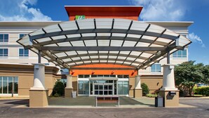 A modern hotel entrance with a covered walkway, large windows, and a prominent entrance door. - Holiday Inn Express Lexington North-Georgetown by IHG (Georgetown)