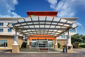 A modern hotel entrance with a covered walkway, large windows, and a prominent entrance door. - Holiday Inn Express Lexington North-Georgetown by IHG (Georgetown)