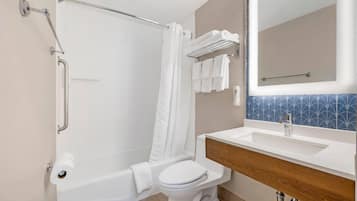 A modern bathroom with a bathtub, toilet, and vanity.