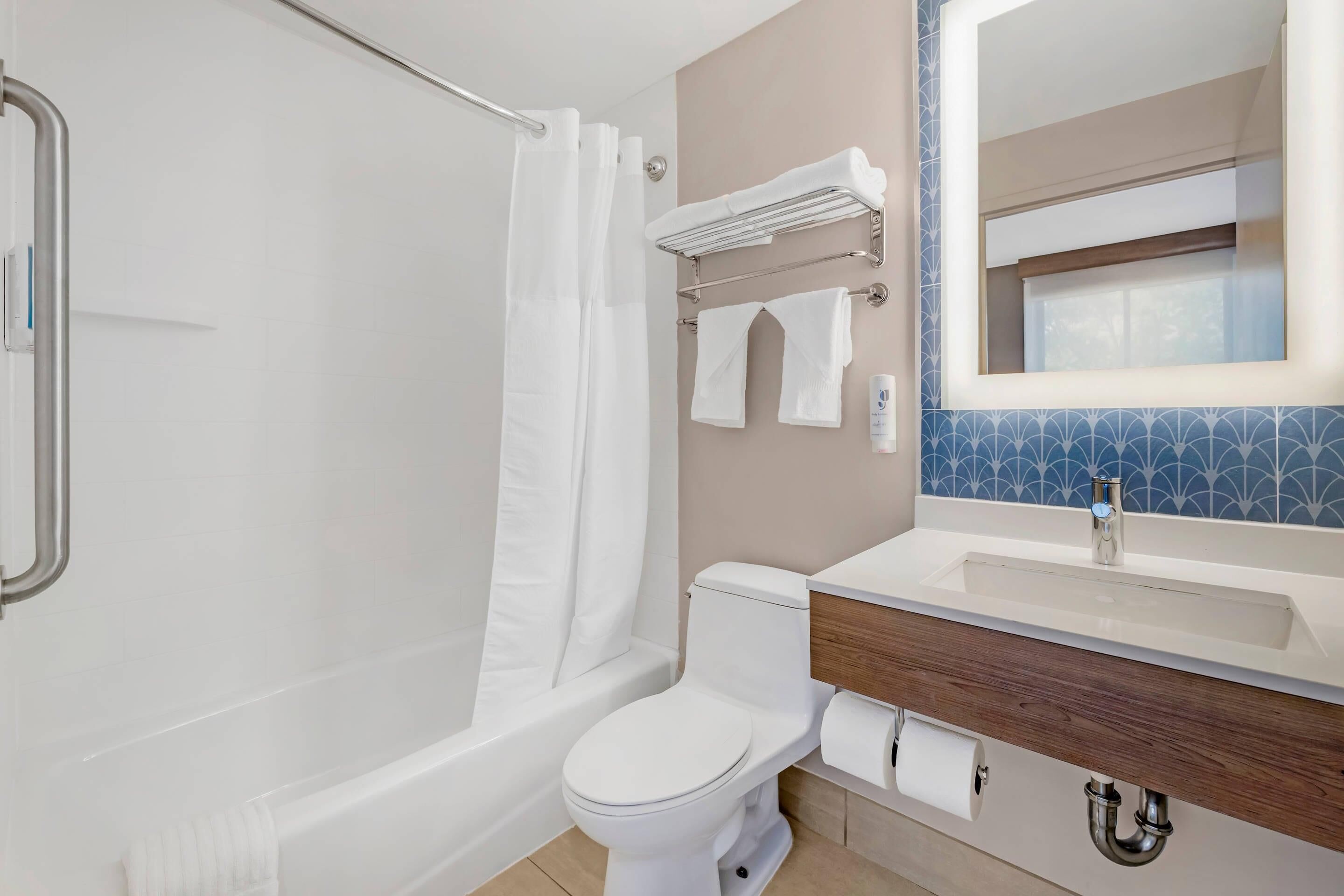A modern bathroom with a bathtub, toilet, and sink.