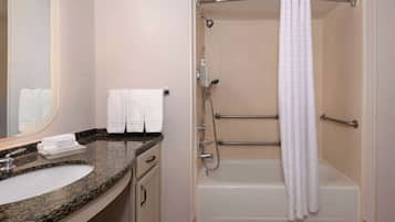 A bathroom with a sink, mirror, towel rack, shower, and bathtub.