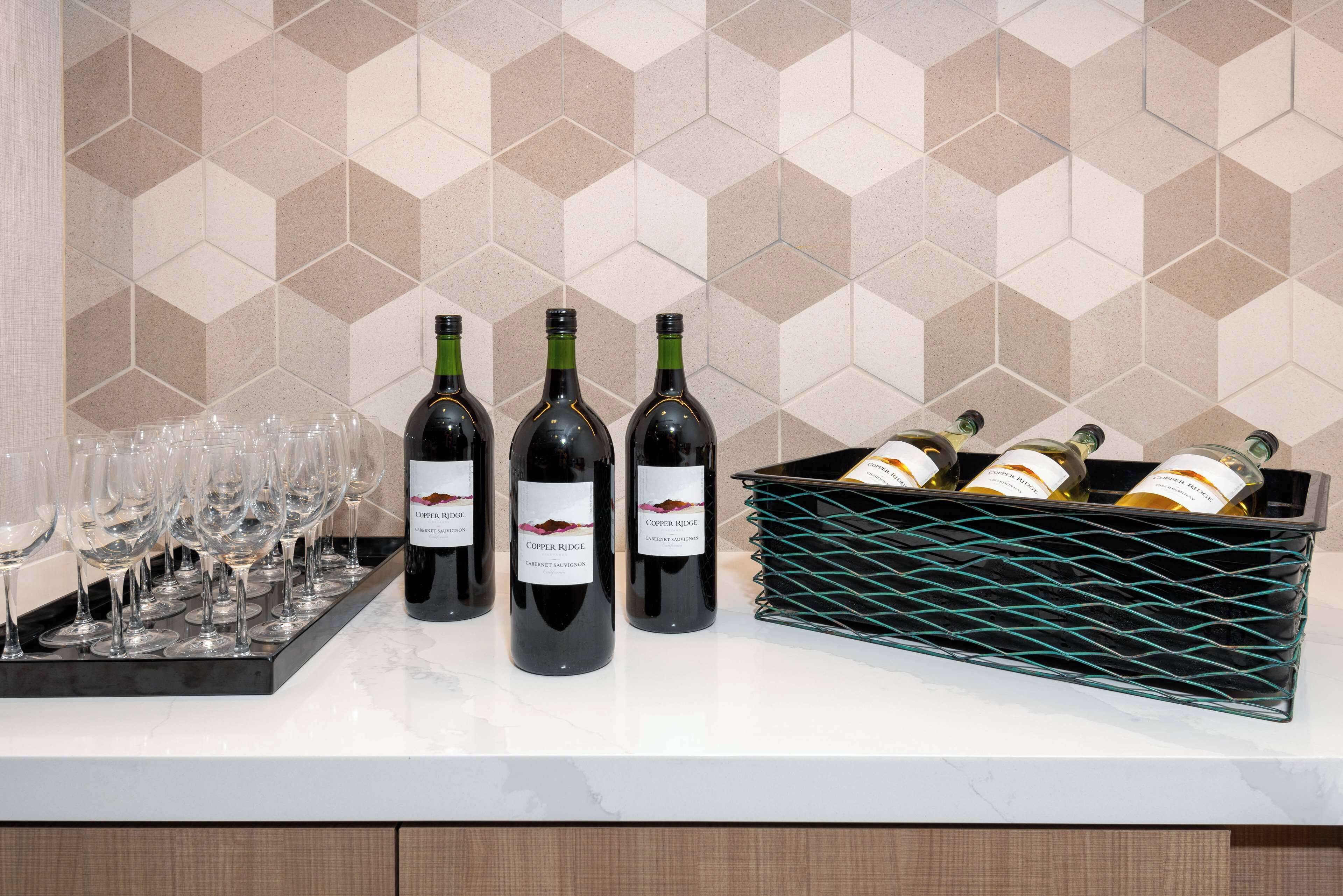 A wine display with bottles and glasses on a countertop.