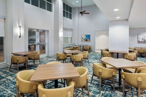 Relax in a spacious room with a large seating area and natural light pouring in through large windows.