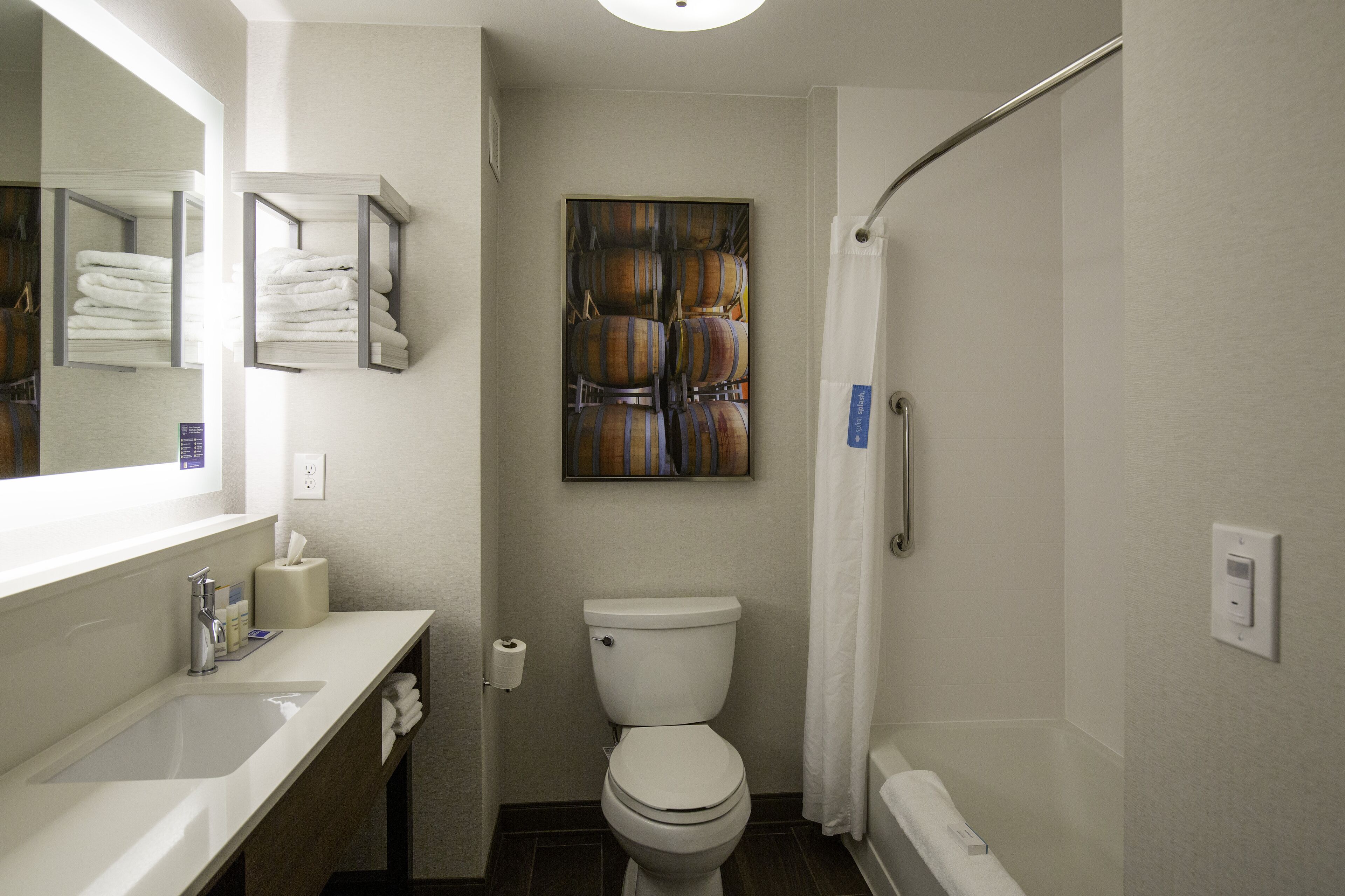 Un baño moderno con inodoro, lavamanos y ducha.