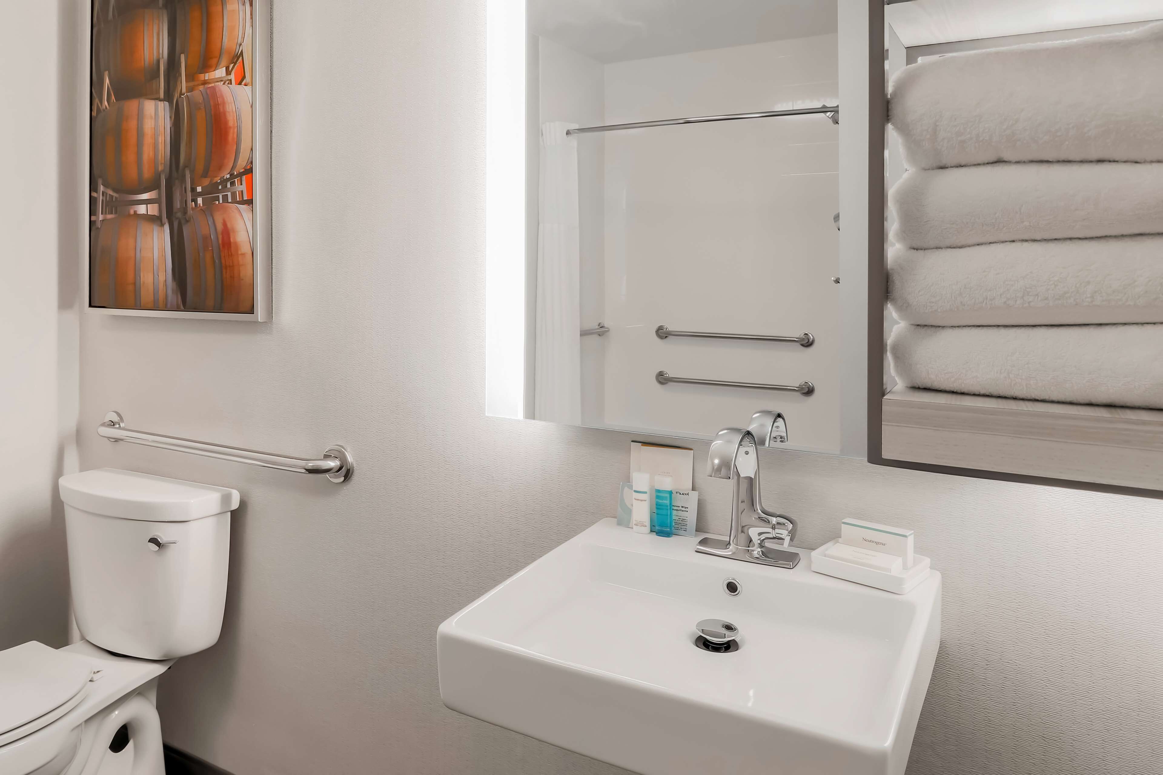 A modern bathroom with a toilet, sink, and towel rack.